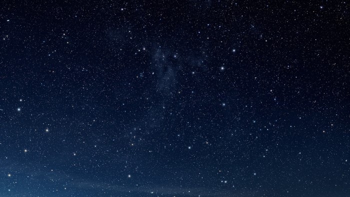 Night sky full of stars and a faint galaxy