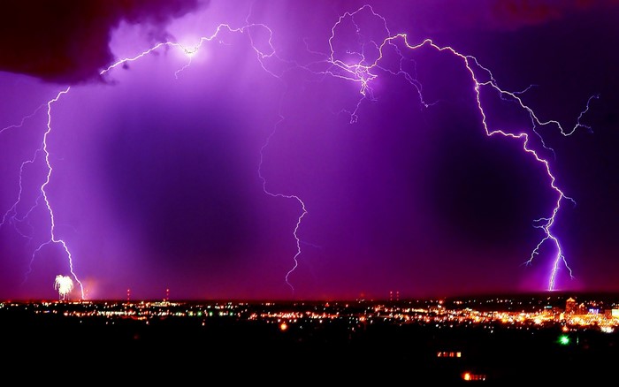 Lightning strikes over a city at night