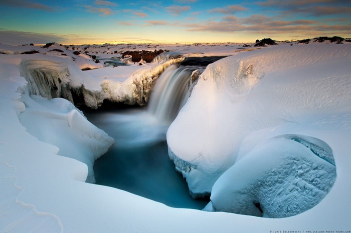 Frozen waterfall in Iceland during sunrise