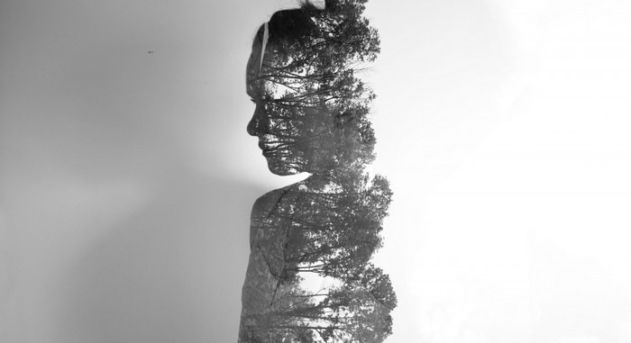 Double exposure of a woman's profile and trees