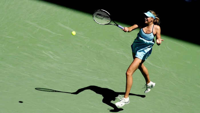 Maria Sharapova playing tennis on a green court