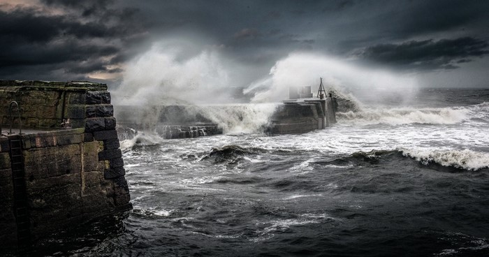 Stormy seas crashing against a stone pier