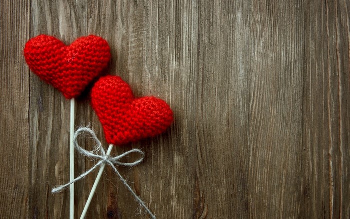 Two red crochet hearts on sticks with twine