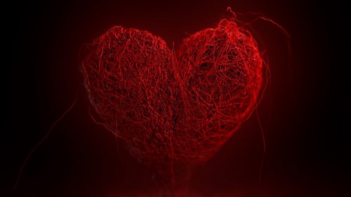 Red heart made of threads on a dark background