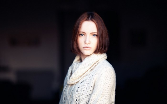 Woman with short brown hair wearing a cream sweater