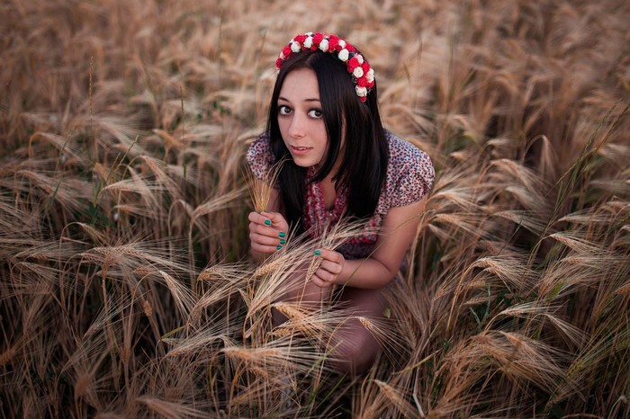Woman with flower crown in a wheat field