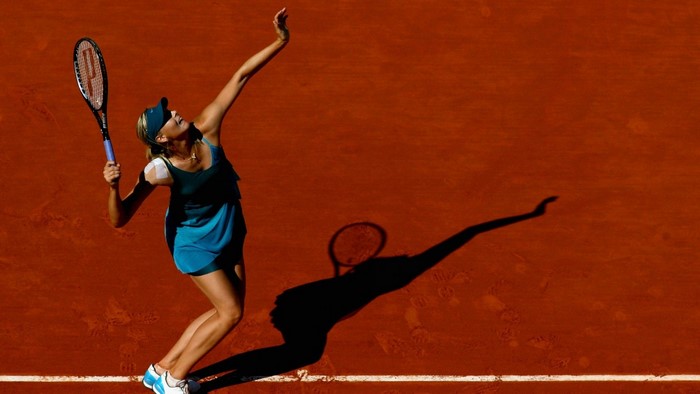 Maria Sharapova serving on a clay tennis court