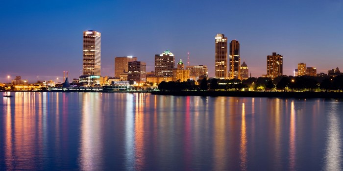 Milwaukee skyline at night with reflections on the water