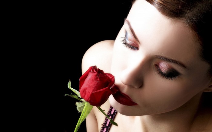 Woman smelling a red rose