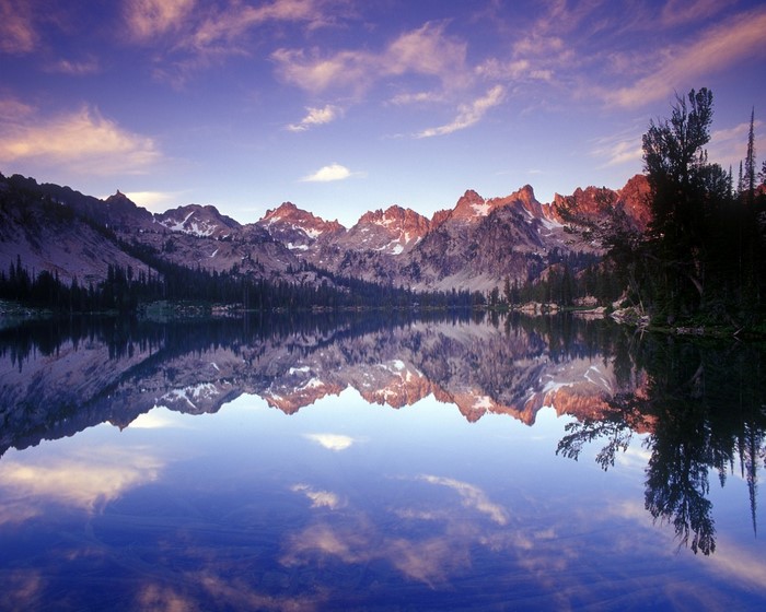 Mountain range reflected in a calm lake at sunset