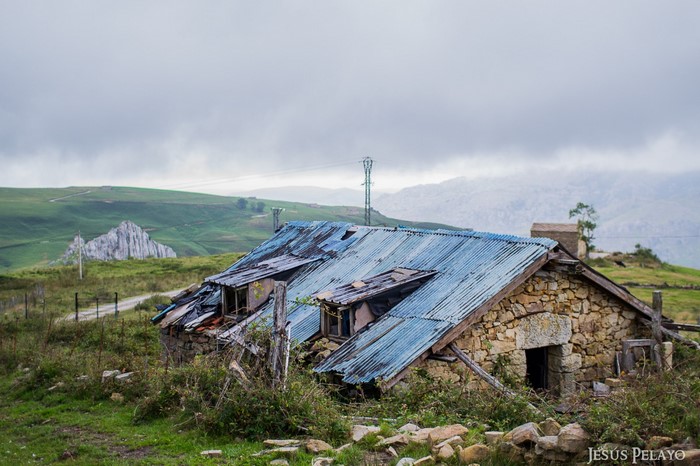 Abandoned stone hut with corrugated roof in Cantabria, Spain