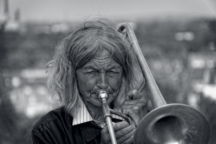Monochrome portrait of an elderly person playing the trombone