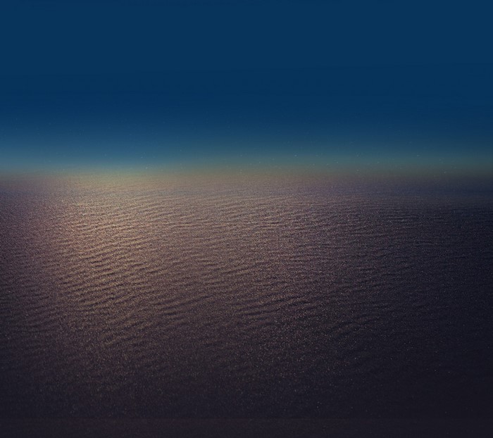 Rippled sand under a dark blue sky