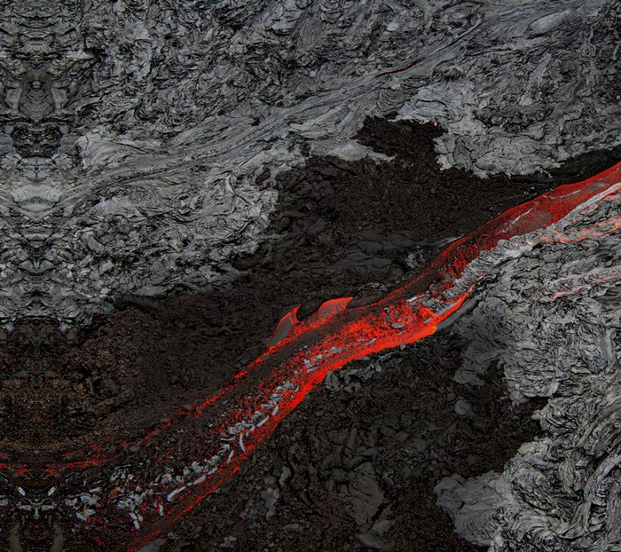 Aerial view of flowing lava over volcanic rock