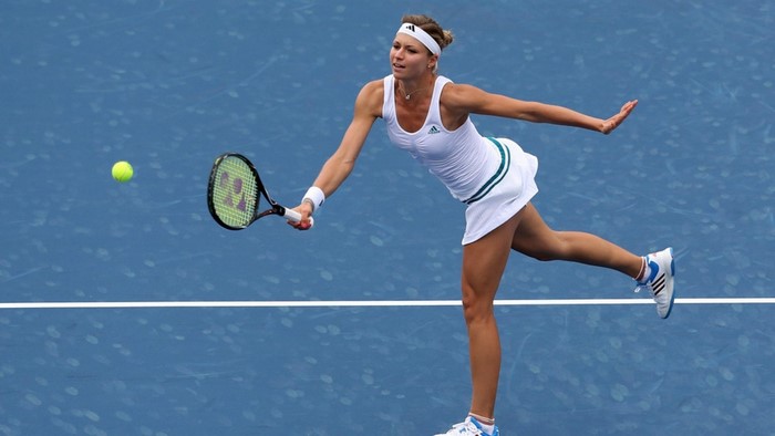 Maria Kirilenko playing tennis on a blue court