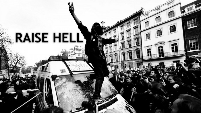 Protester on top of a police van with crowd