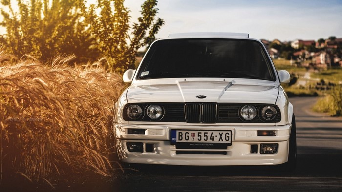 White BMW E30 coupe in a field of wheat