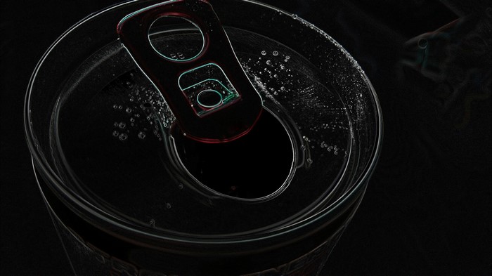 Close-up of an open soda can with bubbles