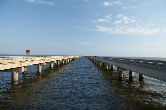 Twin bridges over water with blue sky