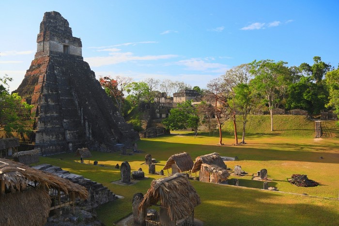 Ancient Maya ruins with pyramids and thatched huts in Tikal, Guatemala