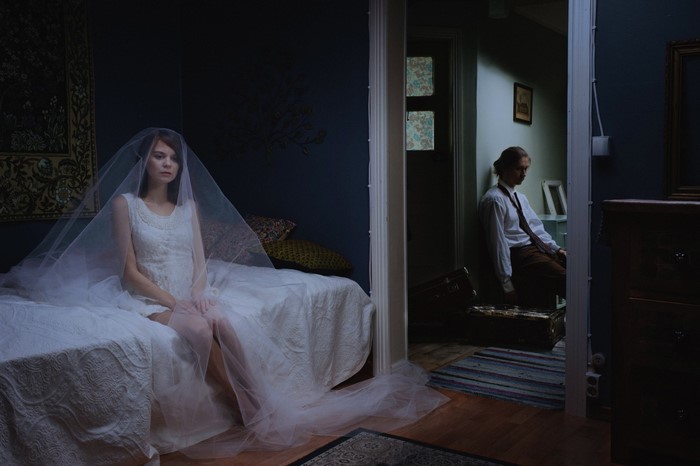 Bride in wedding dress and man with suitcase