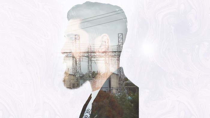 Double exposure of a man's profile and a power station