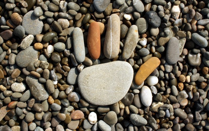 Pebbles arranged in a hand shape on a beach