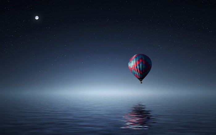 Hot air balloon over water at night with moon and stars