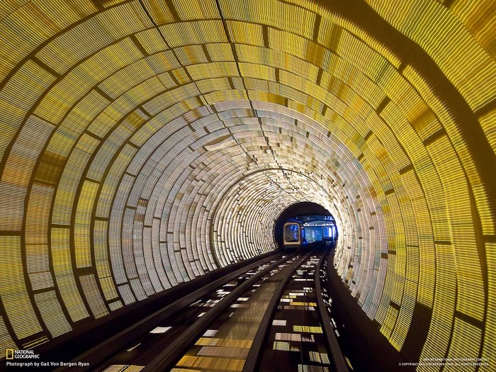 Train in illuminated tunnel with patterned walls
