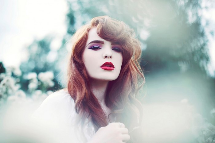 Woman with red hair and dramatic makeup
