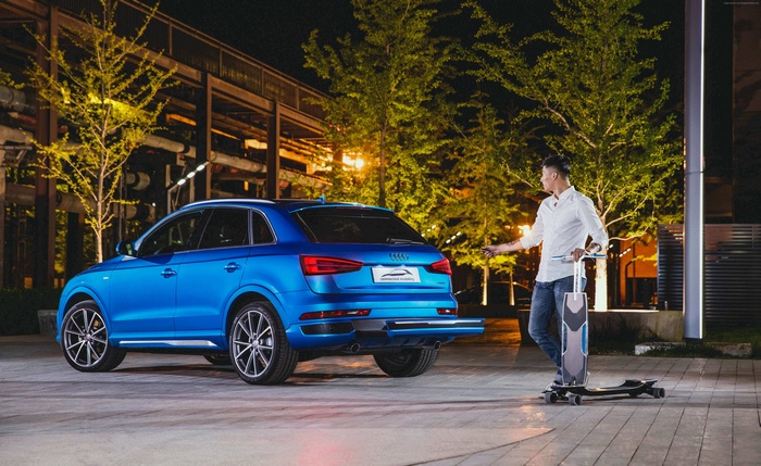 Man with electric scooter next to blue Audi Q3