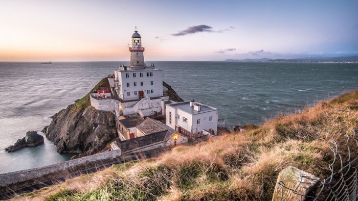 Lighthouse on Rocky Irish Coast at Sunset