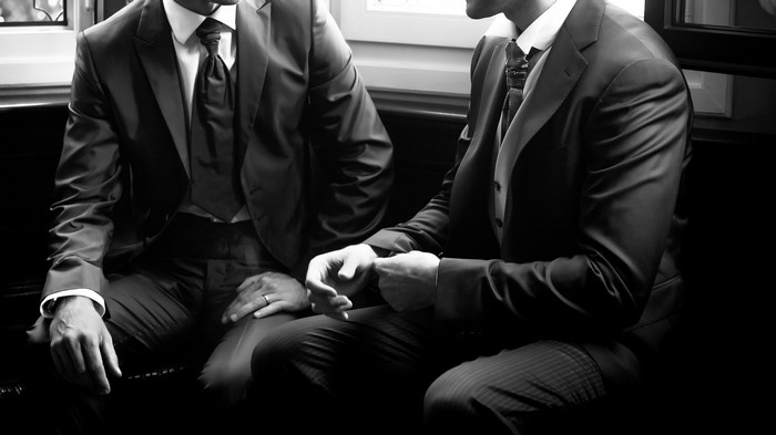 Two men in suits sitting together