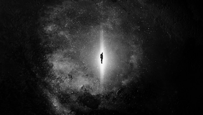 Silhouette of a person in a beam of light in space