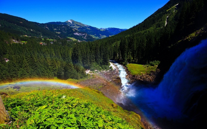 Waterfall with Rainbow and Forested Mountains