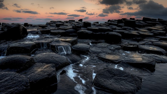 Giants Causeway landscape at sunset with water flowing over rocks
