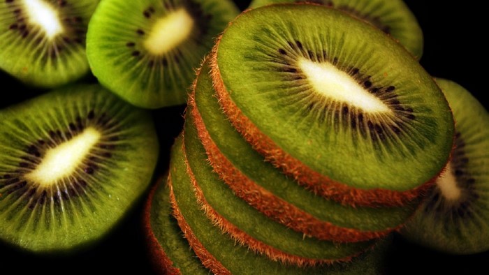 Stack of sliced kiwis with fuzzy brown skin