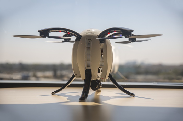 White drone with four propellers on a table