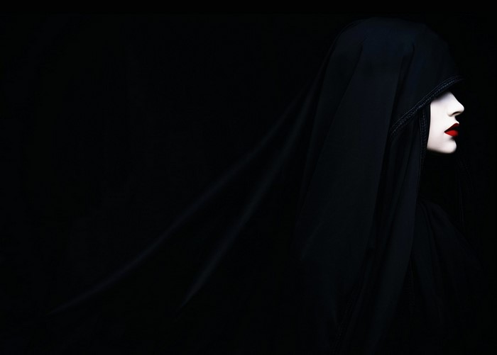 Woman in black veil with red lips in profile