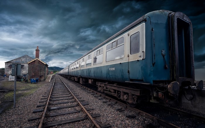 Old blue and white passenger train on tracks