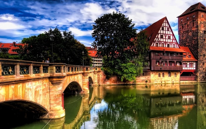 Old stone bridge over a river with historic buildings