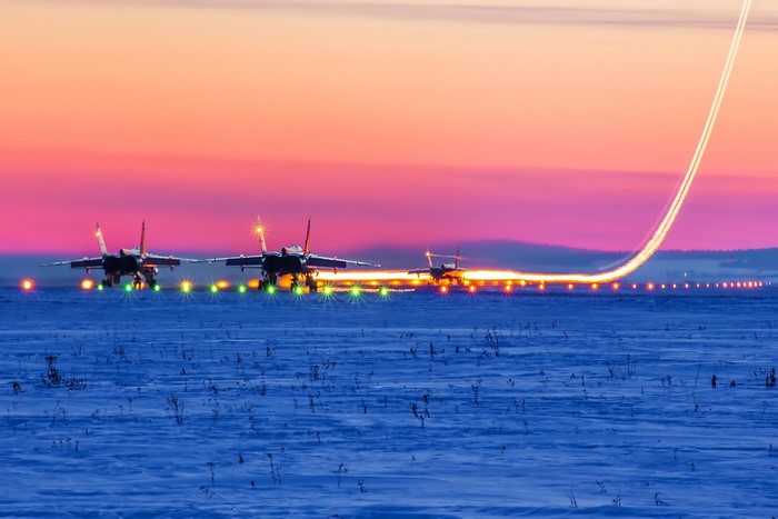 MiG-31 military aircraft on snowy runway at sunset