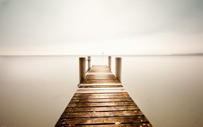 Wooden pier on a calm lake under an overcast sky