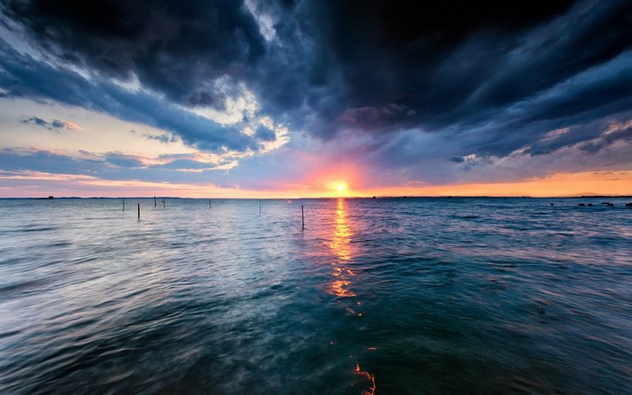 Sunset over the sea with dark clouds