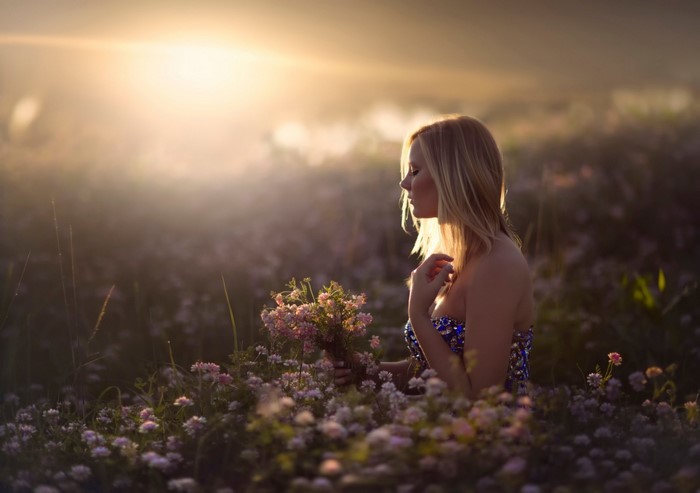 Woman in a field of flowers at sunset