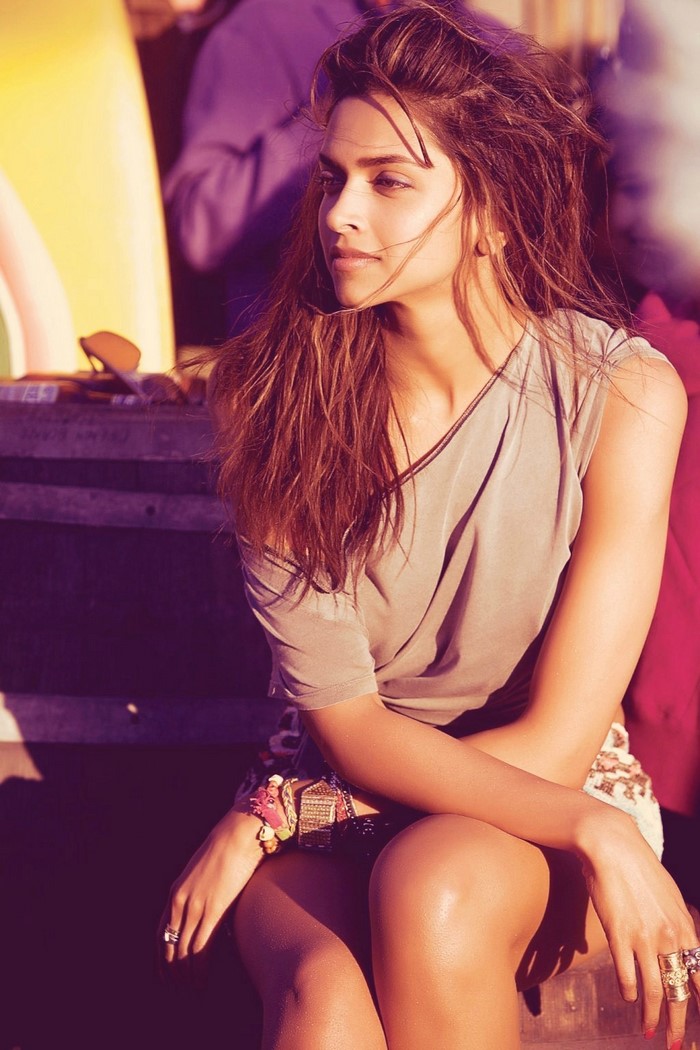 Deepika Padukone sitting outdoors with surfboards