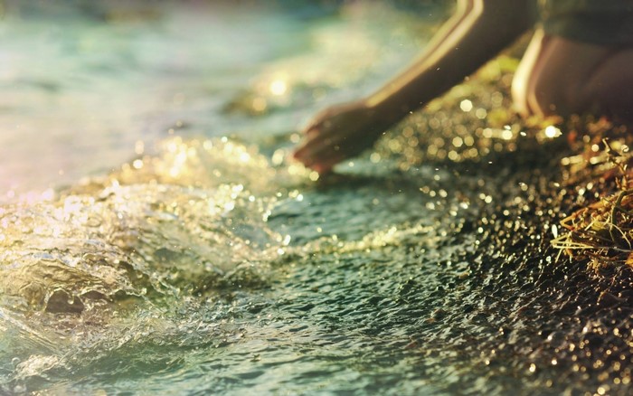 Person kneeling by the water's edge