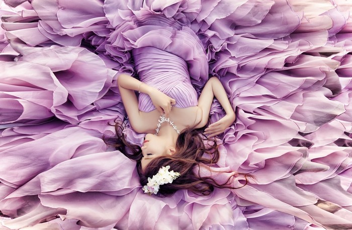 Woman in a voluminous purple dress with flowers