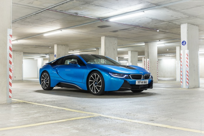 Blue BMW i8 parked in a concrete parking garage