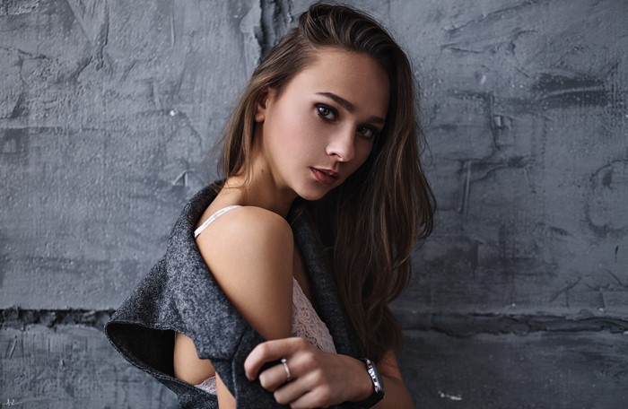 Woman with long brown hair wearing a grey cardigan